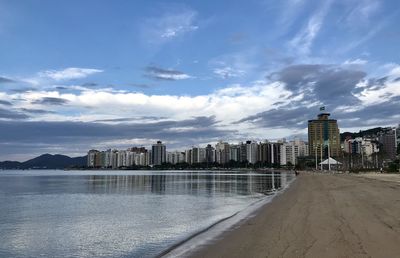 Panoramic shot of sea and buildings against sky