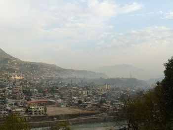 Aerial view of buildings in city against sky