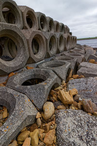 Close-up of stack of rocks by sea against sky