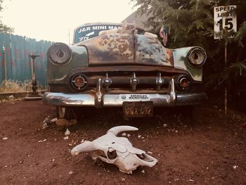 View of abandoned car on field