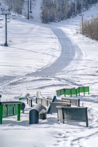 Empty chairs on snow covered field during winter