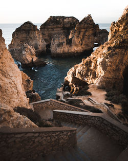 Rock formations by sea against sky