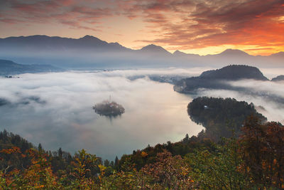 Scenic view of sea and mountains against sky during sunset