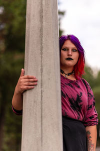 Beautiful gothic woman leaning on light post