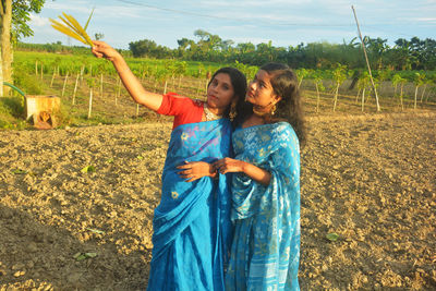 Happy friends standing on field