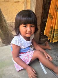 Portrait of smiling girl sitting outdoors