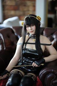 Portrait of young woman sitting on sofa at home