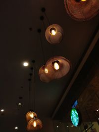 Low angle view of illuminated chandelier hanging on ceiling