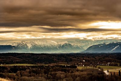 Scenic view of landscape against dramatic sky during sunset