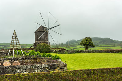 Traditional windmill on field against sky