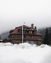 Snow covered landscape and houses against sky