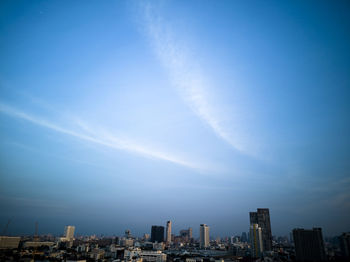 Buildings in city against blue sky