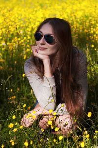 Beautiful young woman wearing sunglasses on field