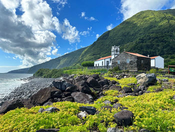 Buildings by sea against sky