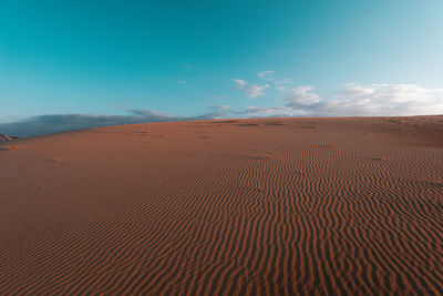 Scenic view of desert against blue sky