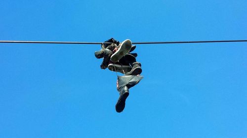 Low angle view of man against clear blue sky