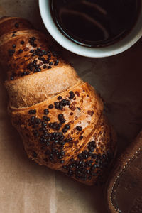 A cup of black morning coffee with a chocolate croissant. delicious meal. aesthetics in details.