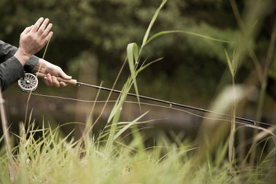 Midsection of person fly fishing