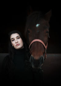 Portrait of beautiful young woman with horse