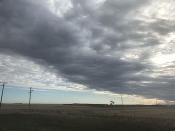 Scenic view of field against cloudy sky