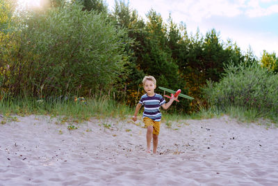 Caucasian little boy launching toy plane into the air