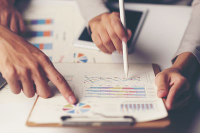 Midsection of man reading book on table