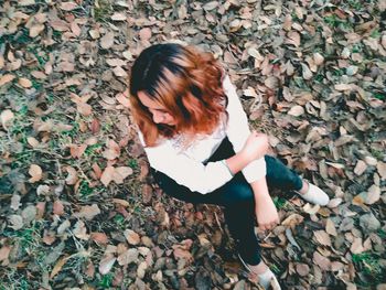 High angle view of woman sitting outdoors during autumn