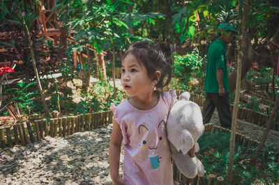 Girl looking away while standing outdoors