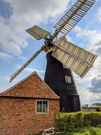 Low angle view of traditional windmill against sky