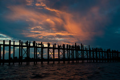 Pier over sea against sky during sunset