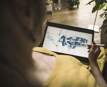 Mature engineer sketching on graphic tablet at home office