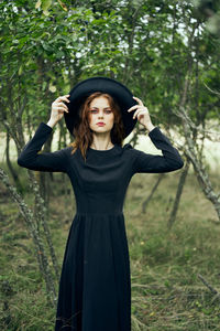 Portrait of young woman standing in forest