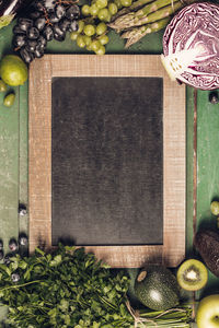 High angle view of vegetables and fruits with blackboard on table