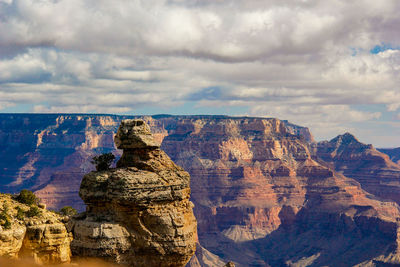 Rock formations against cloudy sky