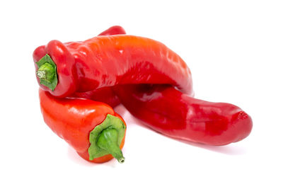 Close-up of red chili peppers against white background