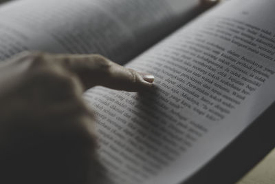 Cropped hand of person writing on book