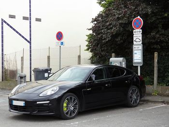 Cars on road against trees in city