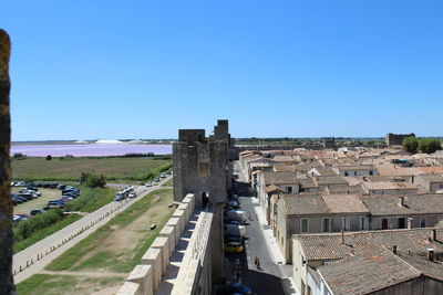 Buildings in city against clear blue sky