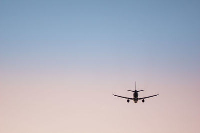 Low angle view of airplane flying against clear sky