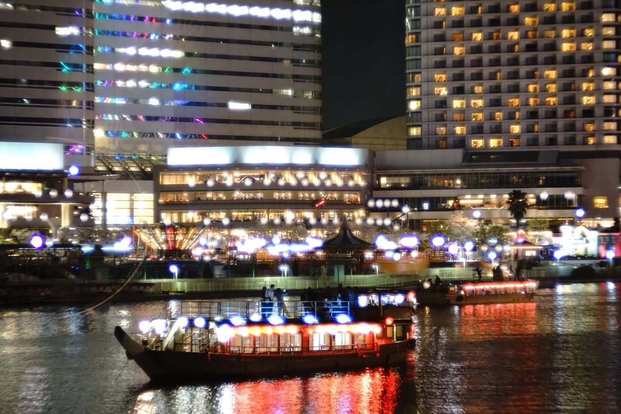 building exterior, architecture, built structure, illuminated, city, transportation, night, waterfront, mode of transport, water, city life, reflection, river, nautical vessel, boat, building, street, cityscape, outdoors, travel