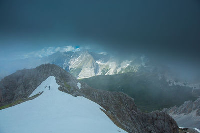 Panoramic view of snowcapped mountains against blue sky