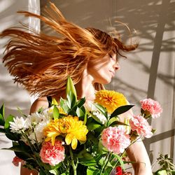 Close-up of woman with pink flowers / woman holding flower bouquet / red head woman