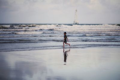 Full length of man on beach against sky