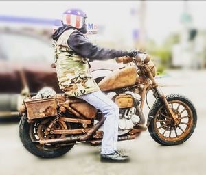 Man riding motorcycle on street in city