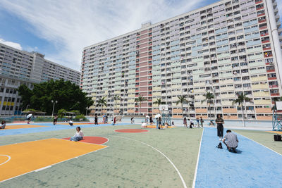 Group of people playing in city against buildings