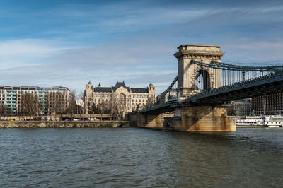 View of bridge over river against cloudy sky