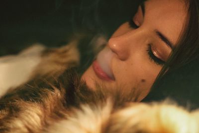 Close-up of young woman emitting smoke
