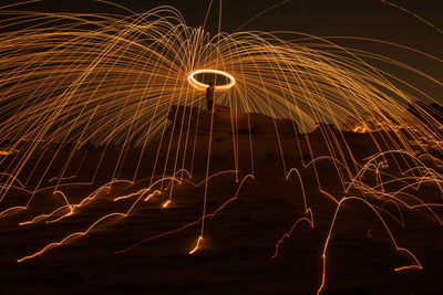 Low angle view of man with wire wool against sky