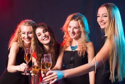 Portrait of a smiling young woman drinking glass