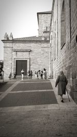 People walking on street against buildings in city